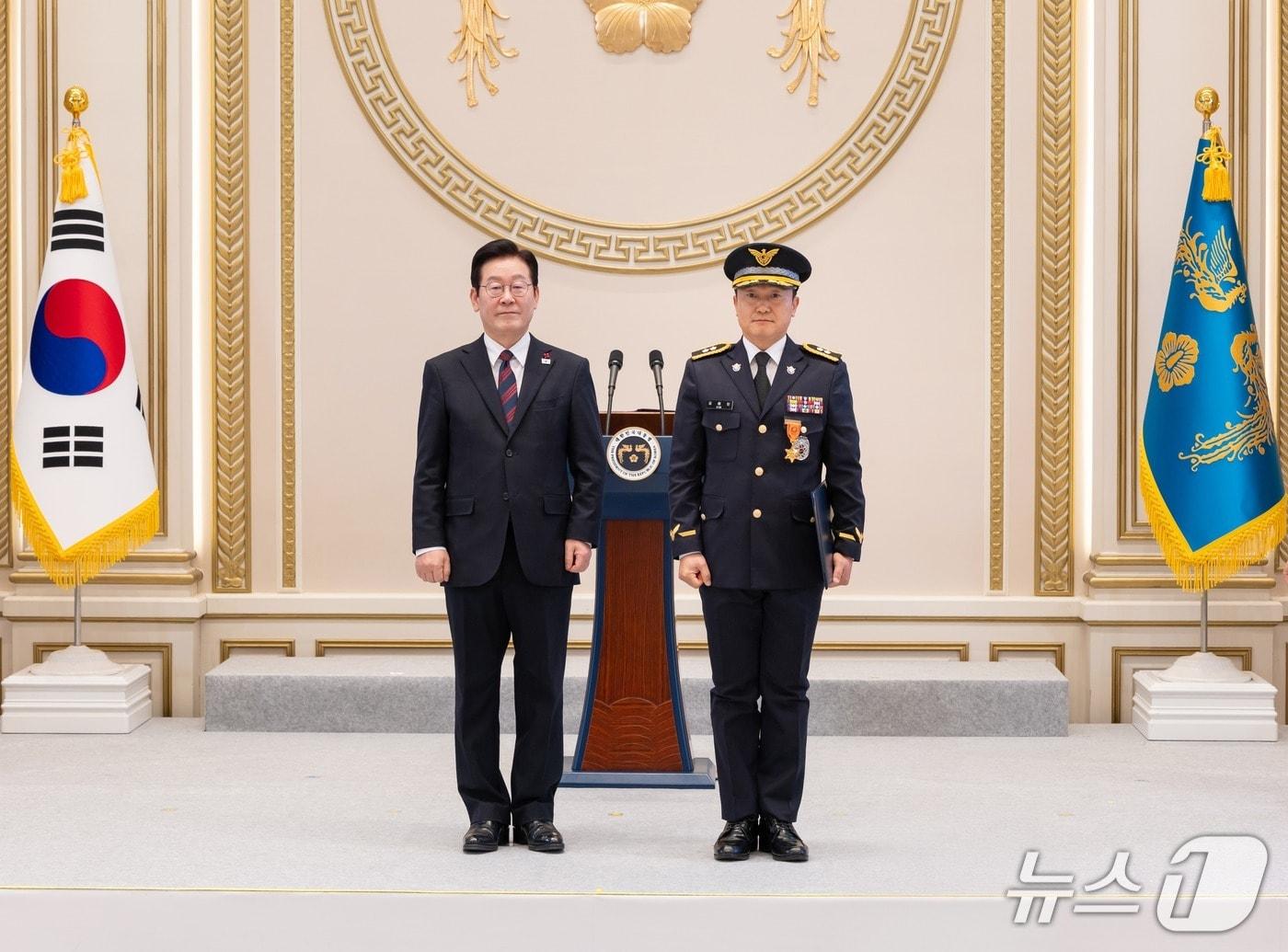 본문 이미지 - 김해인 경감(사진 오른쪽)이 이재명 대통령과 기념 사진을 촬영하고 있는 모습(해양경찰청 제공/뉴스1)