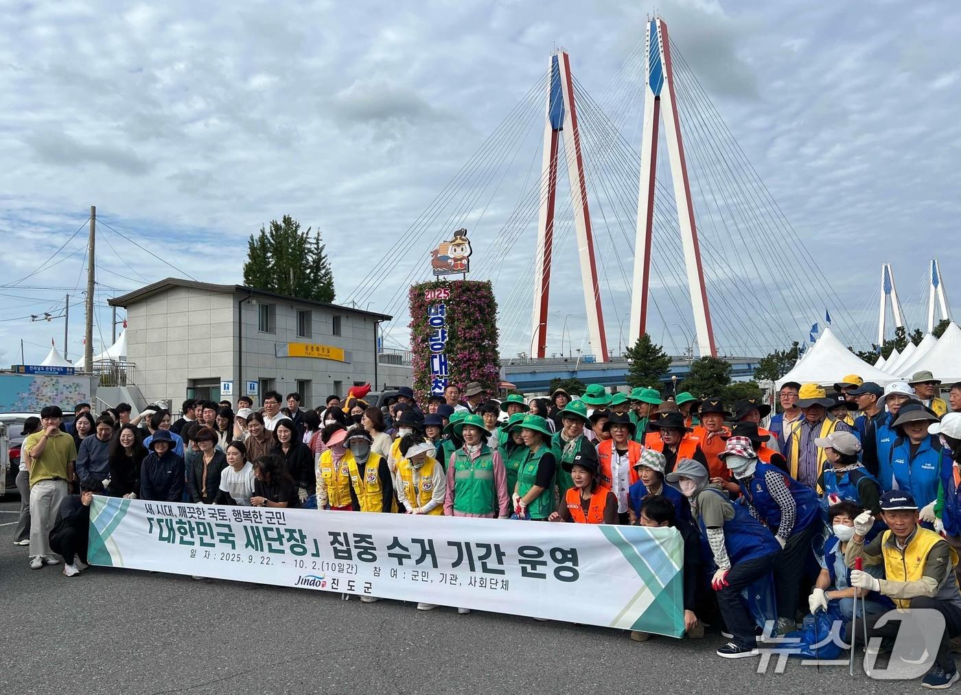 본문 이미지 - 진도군청 공무원과 사회단체, 지역 주민 등이  환경정화 활동을  벌인 뒤 기념사진을 찍고 있다.(진도군 제공.,재판매 및 DB 금지)/뉴스1