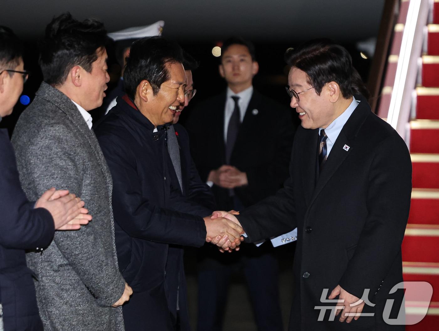 본문 이미지 - 중국 국빈방문 일정을 마치고 귀국한 이재명 대통령이 지난 7일 성남 서울공항에서 환영 나온 정청래 더불어민주당 대표와 인사하고 있다. 2026.1.7/뉴스1 ⓒ News1 허경 기자