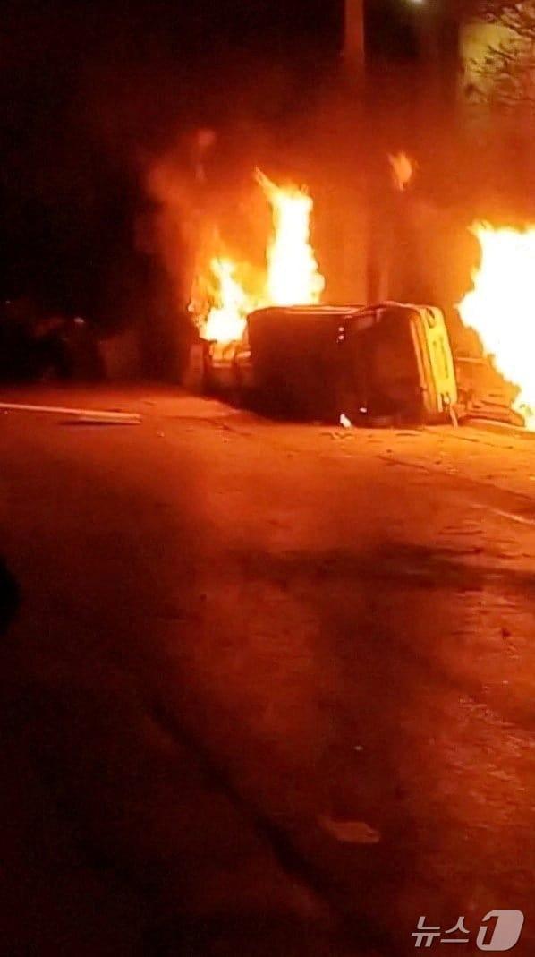 본문 이미지 - 1일(현지시간) 이란 로레스탄주 아즈나에서 경제난에 항의하는 시위가 열린 가운데, 한 경찰서 밖에서 차량이 뒤집히고 불타는 모습. 사진은 소셜미디어 영상 갈무리. 2026.01.01 ⓒ 로이터=뉴스1 ⓒ News1 김지완 기자