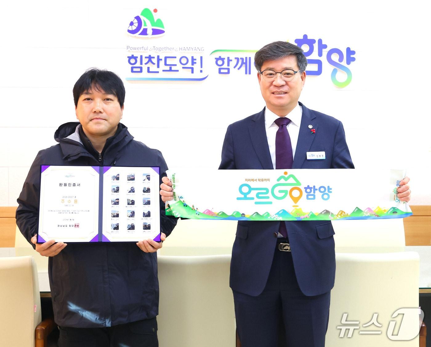 본문 이미지 - ‘오르GO 함양’ 올해 첫 완등자 주수용 씨(왼쪽)가 8일 진병영 함양군수(오른쪽)에게 완등 인증서를 받고 있다(거창군 제공. 재판매 및 DB금지).