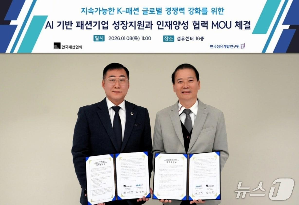 본문 이미지 - 김성만 한국섬유개발연구원장(오른쪽)과 김성찬 한국패션협회 부회장이 '인공지능(AI) 기반 패션기업 성장과 산업구조 혁신 지원 협력'을 위한 업무협약을 체결한 후 협약서를 펼쳐 보이고 있다.(섬유개발연구원 제공, 재판매 및 DB 금지)