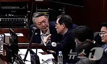 본문 이미지 - 윤석열 전 대통령이 9일 오후 서울 서초구 서울중앙지방법원에서 열린 내란 우두머리 혐의 1심  공판에 출석해 변호인과 대화를 나누고 있다. (서울중앙지방법원 제공 영상 캡쳐. 재판매 및 DB 금지) 2026.1.9/뉴스1