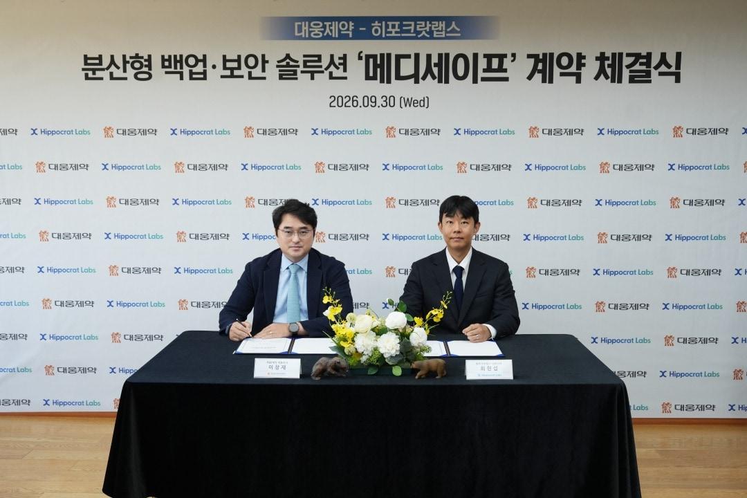본문 이미지 - 이창재 대웅제약 대표(왼쪽)와 최현섭 히포크랏랩스 대표가 계약서에 서명을 하고 있다. (대웅 제공)
