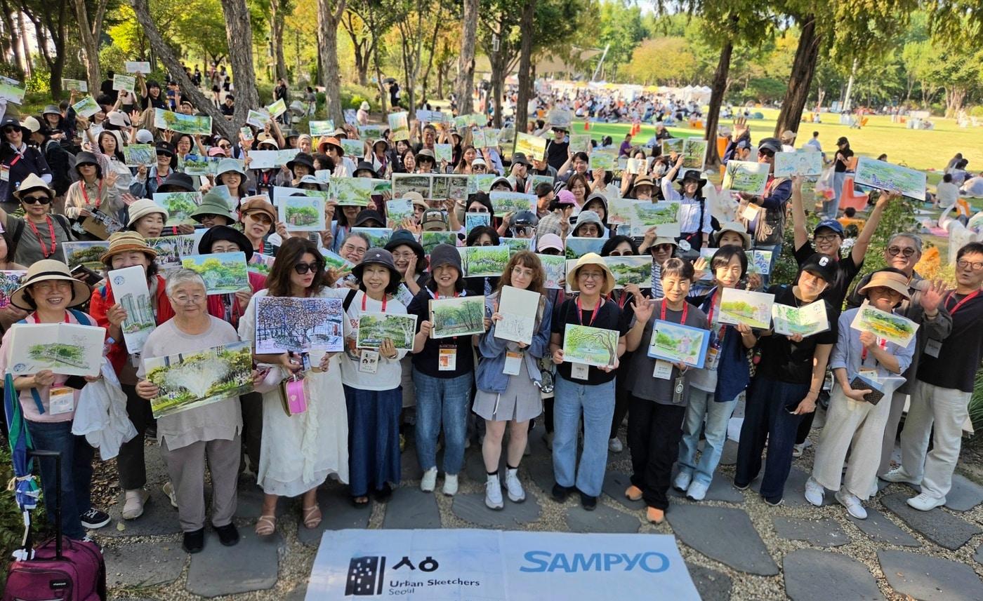 본문 이미지 - 지난 19일 서울숲 내 '삼표 정원'에서 열린 어반스케쳐스 서울 9월 정기모임에서 참가자들이 각자 완성한 그림을 들고 기념 촬영을 하고 있다. (삼표그룹 제공. 재판매 및 DB 금지) 2026.10.1/뉴스1