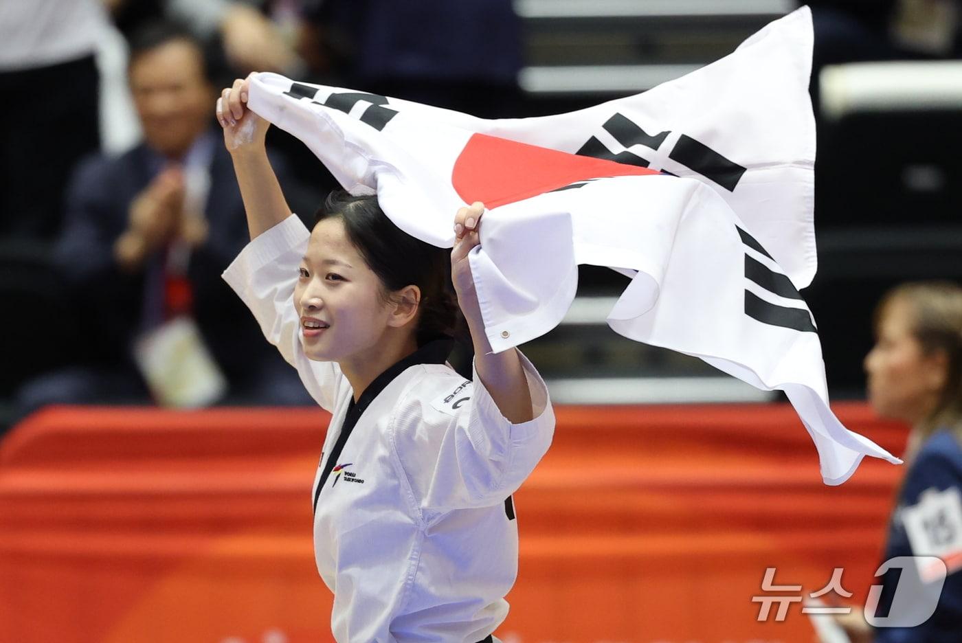 본문 이미지 - 대한민국 정하은이 1일 일본 도요하시 체육관에서 열린 2026 아이치·나고야 아시안게임 태권도 여자 개인 품새 결승전에서 금메달을 확정 후 태극기 세리머니를 하고 있다. 2026.10.1 ⓒ 뉴스1 안은나 기자