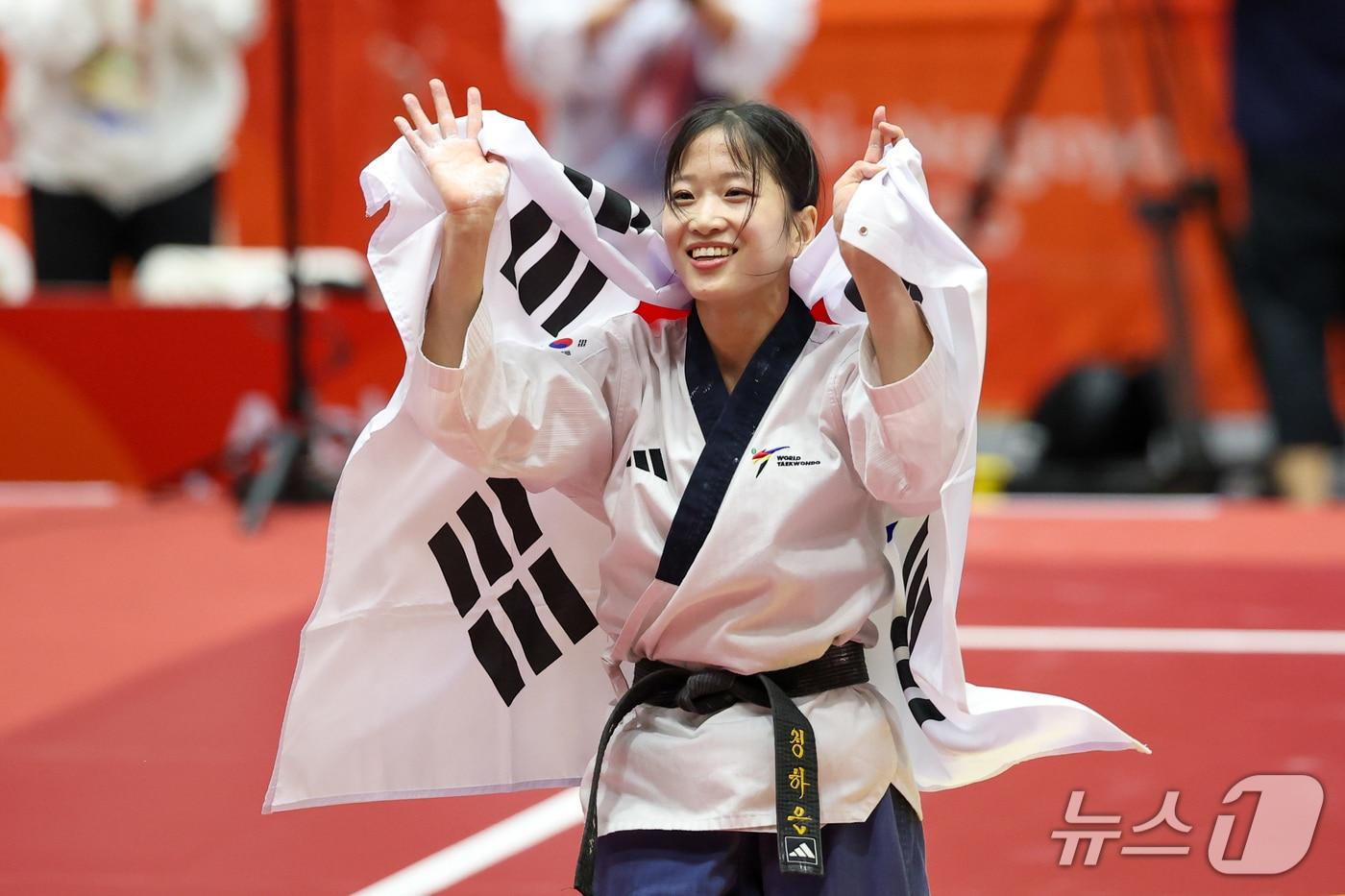 본문 이미지 - 대한민국 정하은이 1일 일본 도요하시 체육관에서 열린 2026 아이치·나고야 아시안게임 태권도 여자 개인 품새 결승전에서 금메달을 확정 짓자 태극기를 둘러메고 큰 절을 한 뒤 기뻐하고 있다. 2026.10.1 ⓒ 뉴스1 안은나 기자