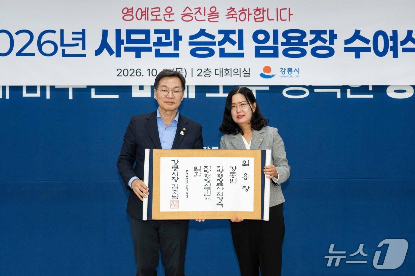 본문 이미지 - 사무관 승진 공무원에게 족자로 된 임용장 전달하고 기념촬영하는 김중남 강원 강릉시장.(왼쪽. 강릉시 제공. 재판매 및 DB 금지) 2026.10.10/뉴스1