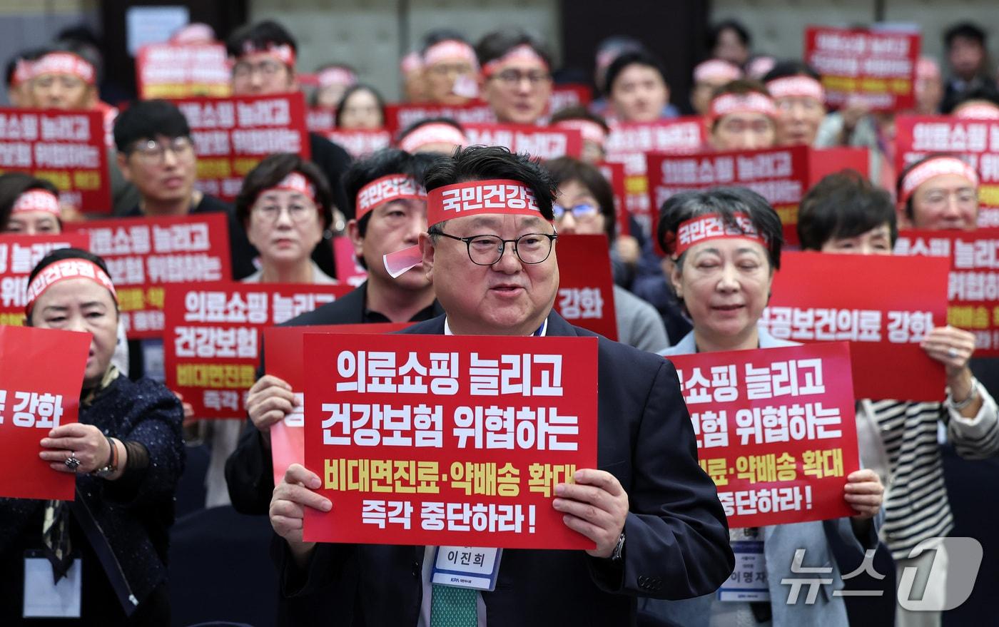 본문 이미지 - 지난 11일 서울 서초구 대한건축사협회 컨벤션홀에서 열린 대한약사회 임시대의원총회에서 약사들이 비대면진료 및 의약품 배송 확대 중단을 촉구하는 구호를 외치고 있다. ⓒ 뉴스1 박지혜 기자