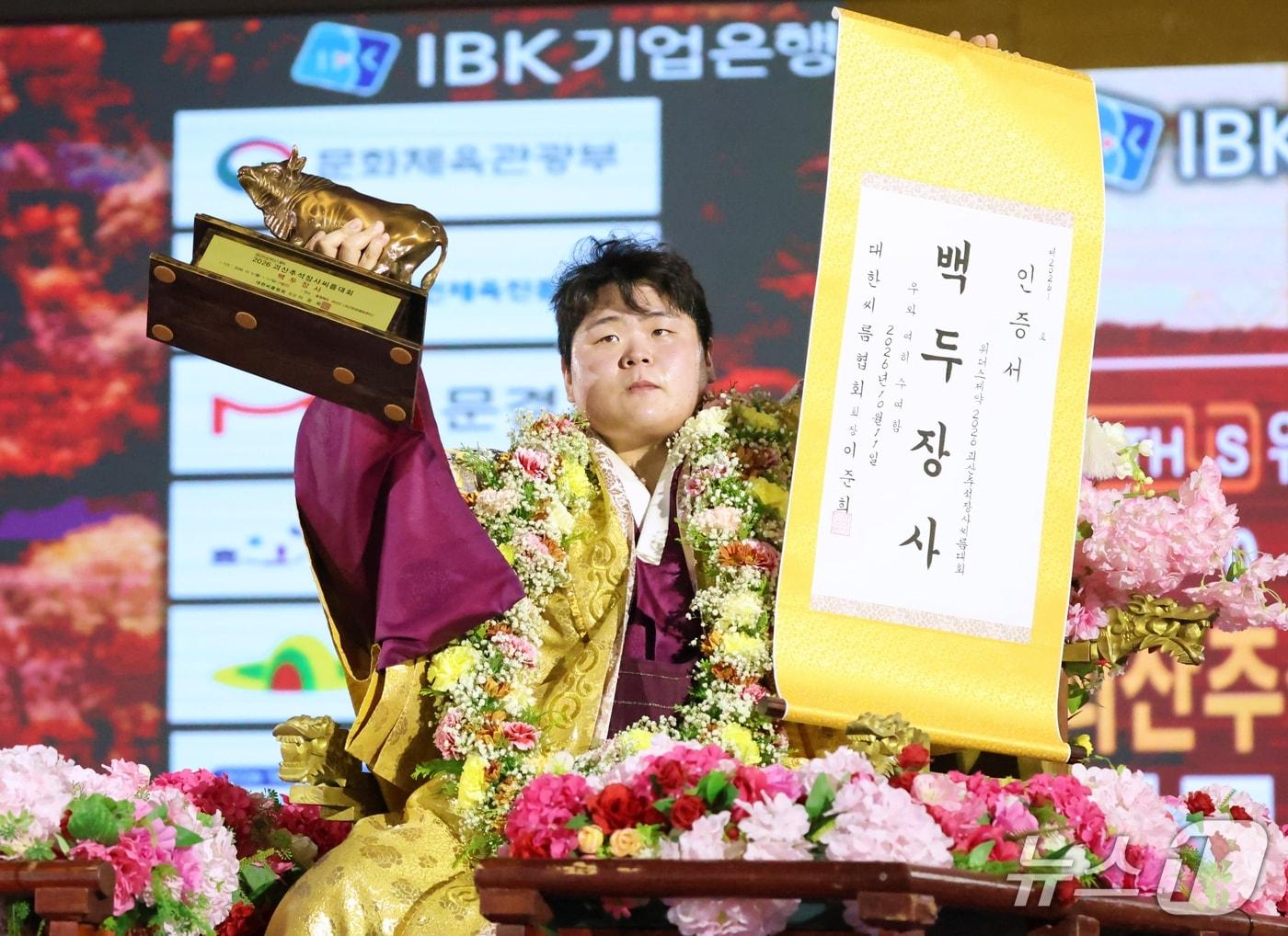 본문 이미지 - 11일 충북 괴산군 괴산문화체육센터에서 열린 '위더스제약 2026 괴산추석장사씨름대회'에서 백두장사(140kg이하)에 등극한 영암군민속씨름단 김민재가 장사인증서와 황소트로피를 들고 기념사진을 찍고 있다. (대한씨름협회 제공. 재판매 및 DB 금지) 2026.10.11 ⓒ 뉴스1