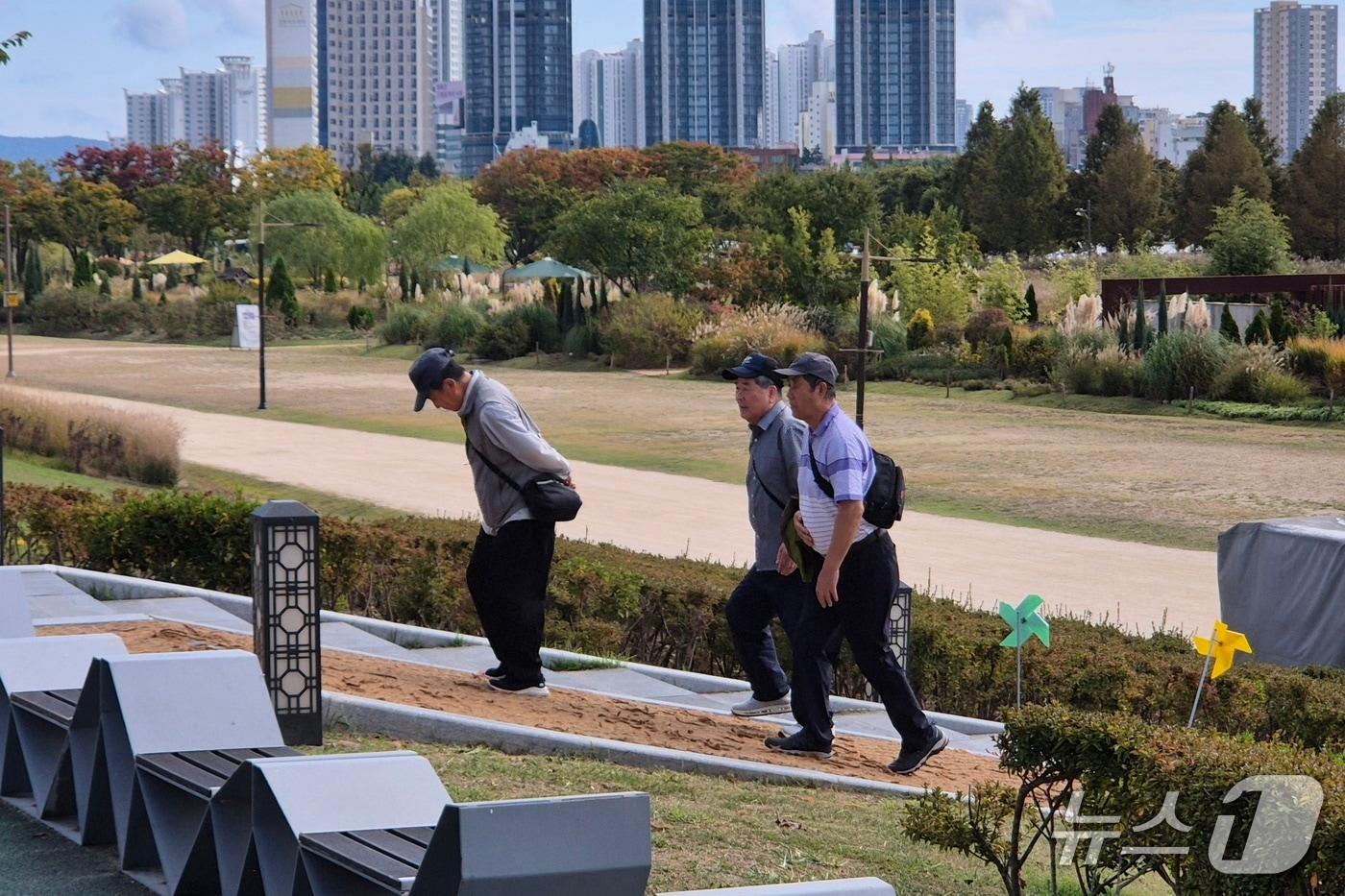 본문 이미지 - 늦더위가 기세를 부린 12일 오전 울산 중구 태화강국가정원에서 시민들이 겉옷을 손에 들거나 가벼운 옷차림으로 산책하고 있다. 2026.10.12 ⓒ 뉴스1 박정현 기자