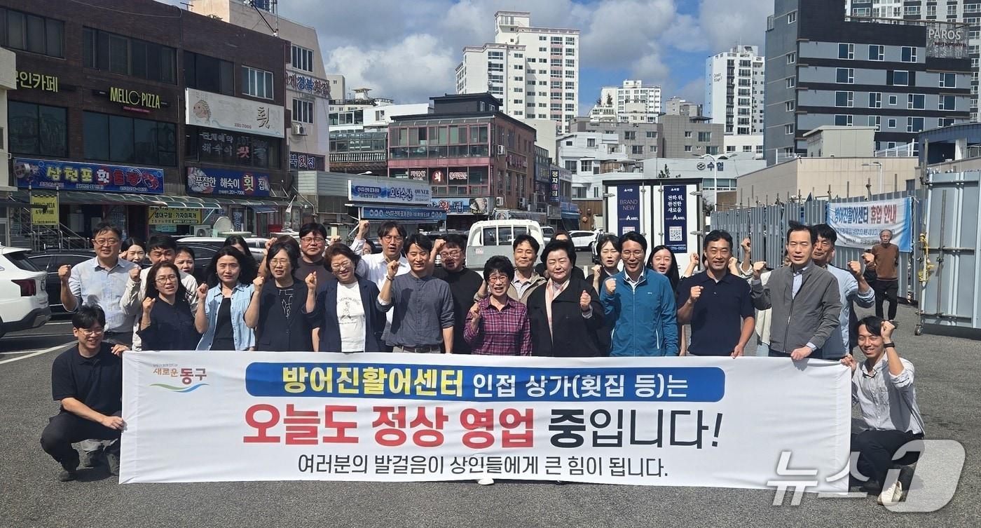 본문 이미지 - 천기옥 동구청장(가운데)과 동구청 직원 등 40여 명이 이날 오전 11시 방어진활어센터 인근에서 상권 활성화 캠페인을 하고 기념사진을 찍고 있다.(울산 동구 제공. 재판매 및 DB 금지)/뉴스1