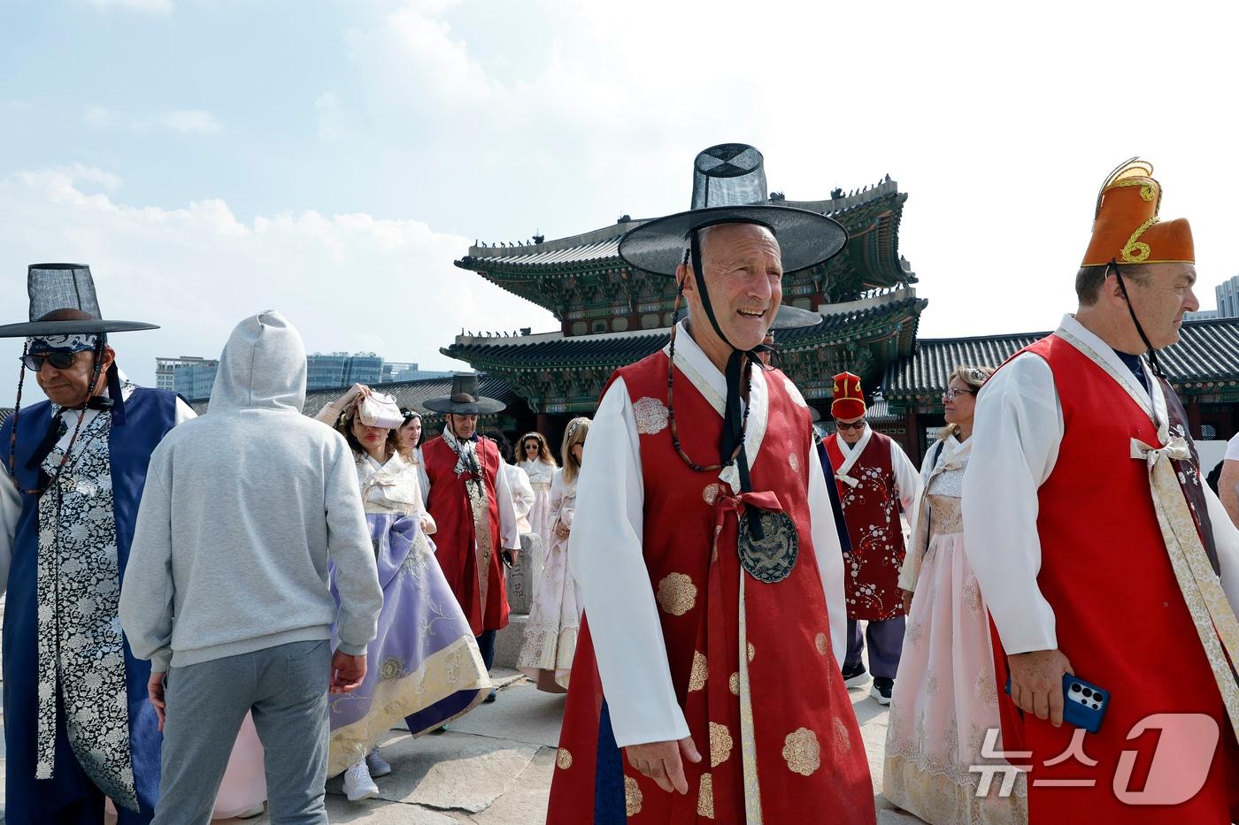 본문 이미지 -  외국인 관광객들이 12일 서울시 종로구 경복궁에서 렌탈 한복을 입고 궁궐을 거닐며 추억을 남기고 있다. 2026.10.12 ⓒ 뉴스1 박정호 기자