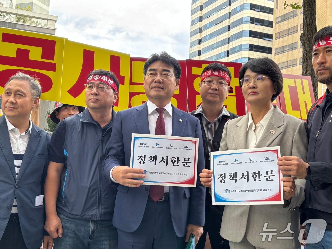 본문 이미지 - (시진 왼쪽 맨 앞줄 세번째부터)이성권 국민의힘 국회의원과 임미애 더불어민주당 국회의원이 12일 국정감사장 앞에서 4대 항만공사 노조로부터 항만공사 통합을 반대하는 취지의 정책서한문을 받고 있는 모습 2026.10.12 ⓒ 뉴스1 홍윤 기자