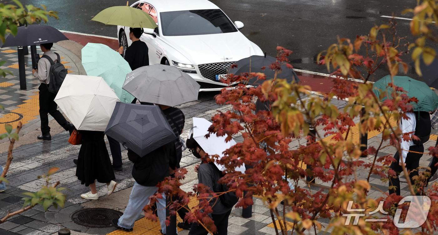 본문 이미지 - 13일 오전 우산을 쓴 시민들이 서울 광화문에서 출근길 발걸음을 재촉하고 있다. 기상청은 오후에 기온이 뚝 떨어지겠다고 예보했다. 2026.10.13 ⓒ 뉴스1 이종덕 기자