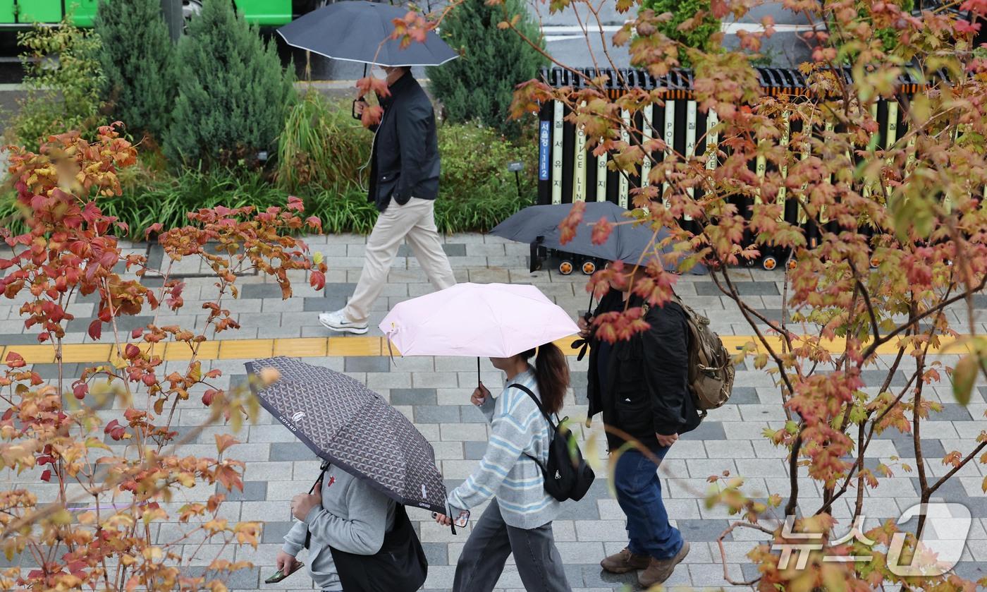 본문 이미지 - 13일 오전 우산을 쓴 시민들이 서울 광화문에서 출근길 발걸음을 재촉하고 있다. 기상청은 오후에 기온이 뚝 떨어지겠다고 예보했다. 2026.10.13 ⓒ 뉴스1 이종덕 기자