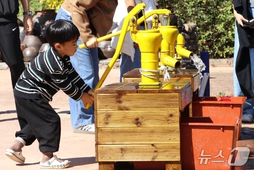 본문 이미지 - 김천 농촌체험 페스티벌에서 한 어린이가 옛날 물 펌프를 체험하고 있다.(김천시 제공. 재판매 및 DB 금지)/뉴스1