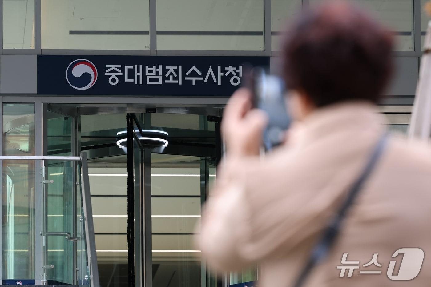 본문 이미지 - 13일 서울 중구 중대범죄수사청 앞에서 한 시민이 현판을 촬영하고 있다. 2026.10.13 ⓒ 뉴스1 안은나 기자