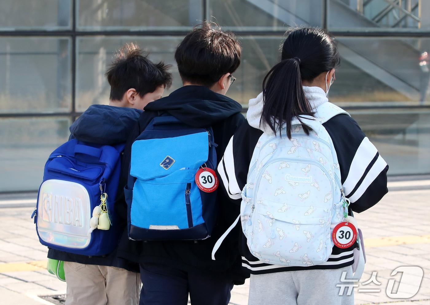 본문 이미지 - 비가 그친 뒤 기온이 크게 내려간 14일 오전 대구 중구 계명네거리에서 긴팔옷을 입은 초등학생들이 등굣길 발걸음을 재촉하고 있다. 책가방에 어린이보호구역(스쿨존) 제한속도는 시속 30㎞를 알리는 키링이 눈길을 끈다. 2026.10.14 ⓒ 뉴스1 공정식 기자
