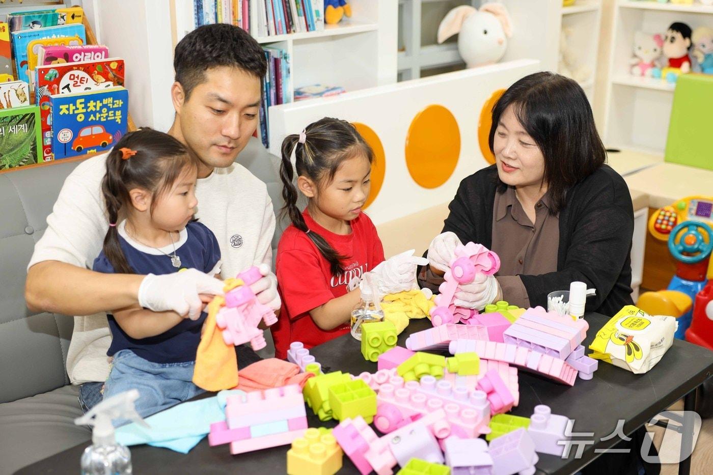 본문 이미지 - 칠곡군 박서아(6)·서율(4) 자매가 아버지 박성우 씨와 함께 아이누리장난감도서관에서 라오스 친구들에게 보낼 장난감을 친환경 알코올로 소독하고 있다.(칠곡군 제공. 재판매 및 DB 금지)/뉴스1