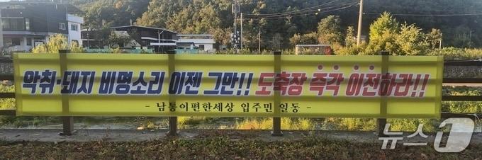 본문 이미지 - 경북 구미시 신기동에 축협이 운영하는 도축장의 이전 촉구하는 플래카드가 내걸려 있다. 주민들은 "악취와 소음 피해가 크다"고 호소했다.2026.10.14/뉴스1