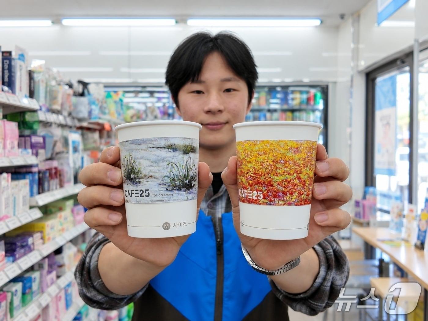 본문 이미지 - 최종원 경영주가 작품을 디자인에 적용한 카페25 컵홀더를 들고 포즈를 취하고 있다.(GS25 제공)