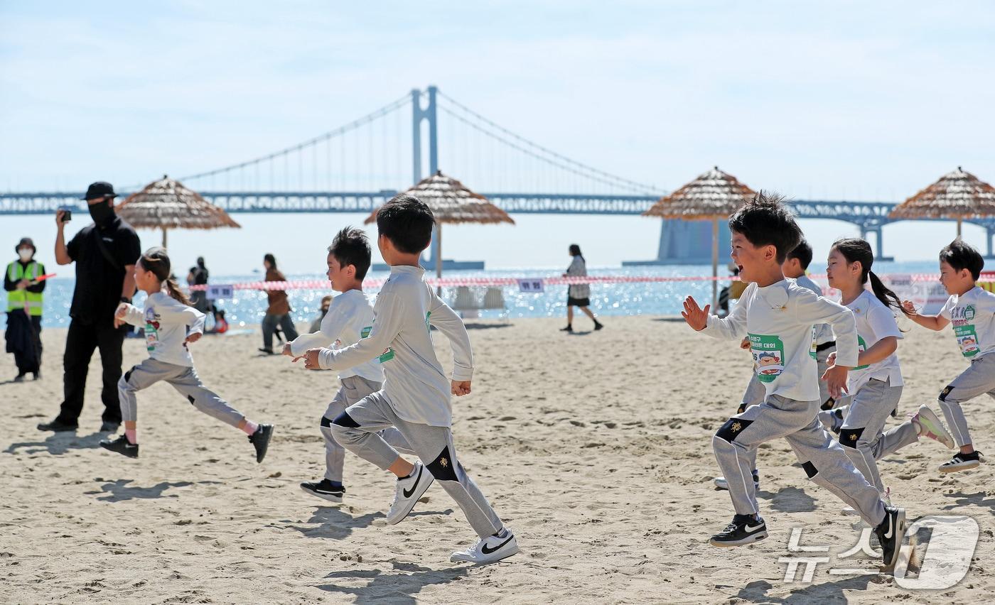 본문 이미지 - 15일 부산 수영구 광안리해수욕장에서 열린 제13회 아이사랑 마라톤 대회에 참가한 어린이들이 해맑게 웃으며 백사장을 달리고 있다. 2026.10.15 ⓒ 뉴스1 윤일지 기자