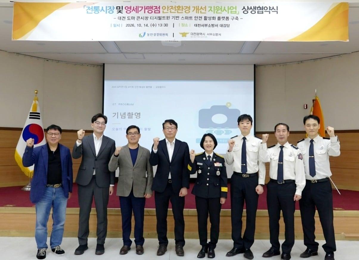 본문 이미지 - 김풍민 토버 대표, 곽재욱 동반성장위원회 운영처장, 백승재 도마큰시장 상인회장, 변태섭 상생협력재단 사무총장, 김옥선 대전서부소방서 서장, 이영규 소방행정과장, 김종삼 재난대응과장, 고택훈 현장대응단장이 기념사진을 찍고 있다.(동반성장위원회·대중소기업농어업협력재단 제공)