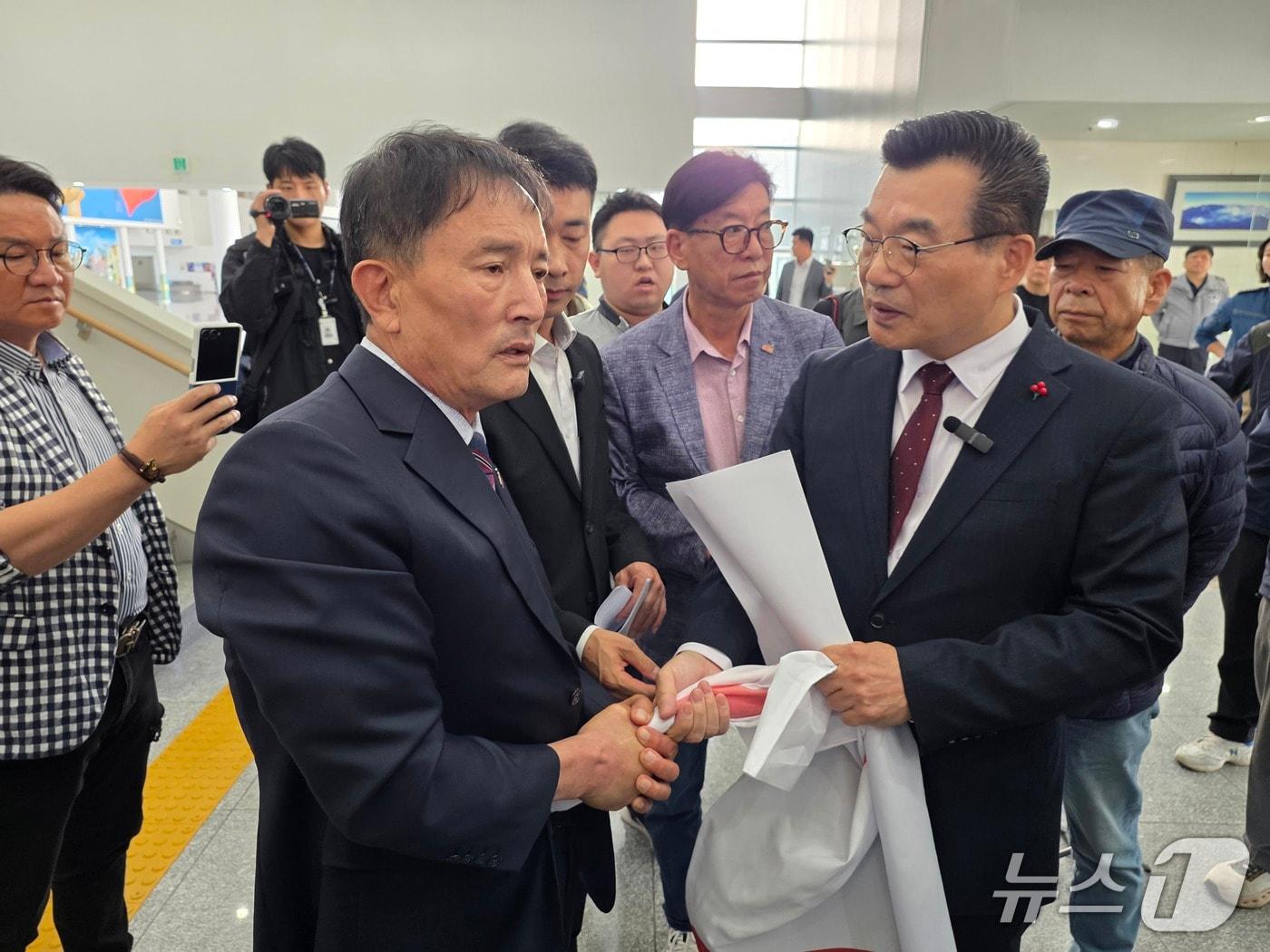 본문 이미지 - 오월단체 회원들이 15일 오후 전남광주통합특별시의회 광주청사 1층에서 5·18 가짜유공자 의혹 검증을 주장하려는 하헌식 국민의힘 서구갑 당협위원장(오른쪽) 기자회견을 저지하며 현수막을 부여잡고 있다. 2026.10.15 ⓒ 뉴스1 서충섭 기자