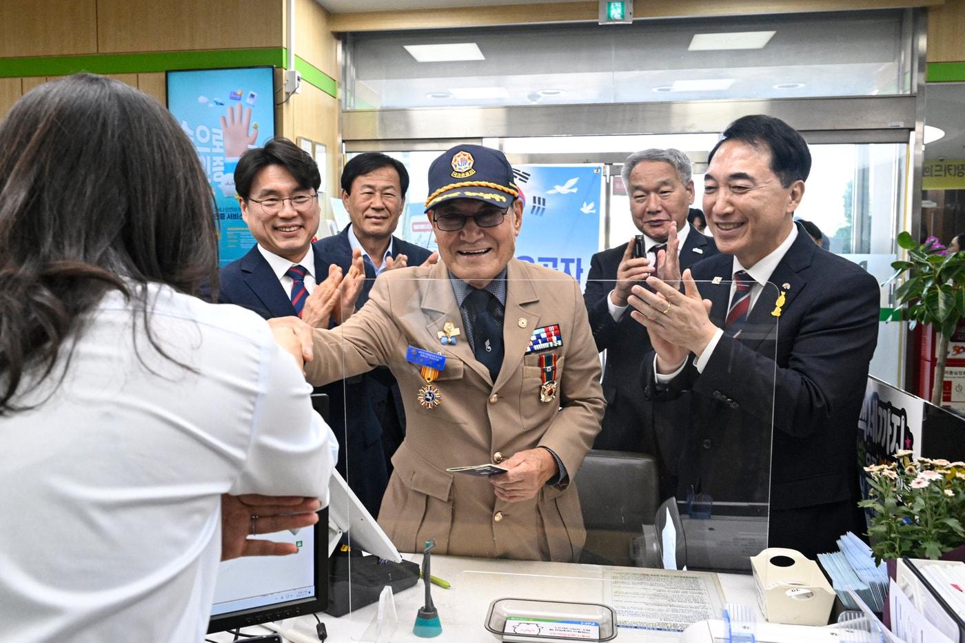 본문 이미지 - 한 국가유공자 어른신이 부여군 규암농협 내 전용 창구를 이용하고, 옆에 선 박수현 지사(오른쪽 첫번째)와 이용우 부여군수(오른쪽 두번째)가 축하하고 있다.(도 제공. 재판매 및 DB 금지)/뉴스1