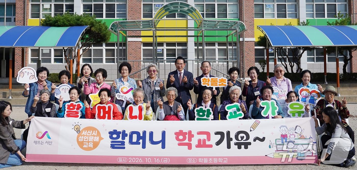 본문 이미지 - 16일 충남 서산시 학돌초등학교에서 열린 ‘할머니 학교가유’ 프로그램에 참여한 성인문해교육 마을학교 어르신들이 이완섭 서산시장 등 관계자들과 함께 손가락 하트를 만들며 기념촬영을 하고 있다.(서산시 제공. 재판매 및 DB 금지)