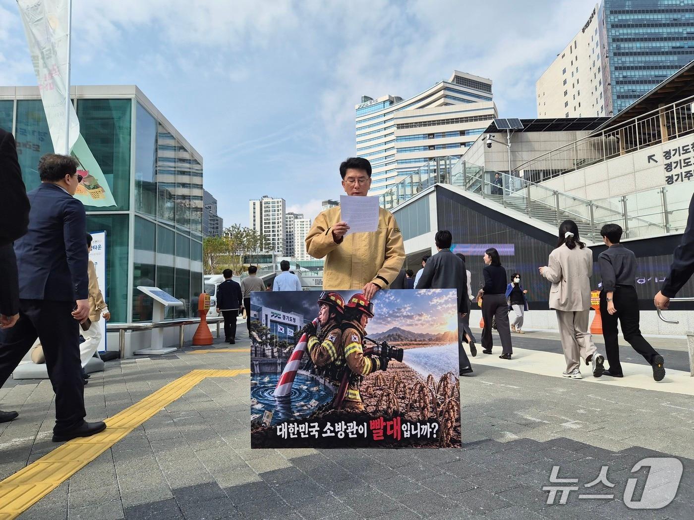 본문 이미지 - 소방관 출신인 윤성근 전 경기도의원이 16일 경기도청 앞에서 추미애 경기도지사 '소방 재정 빨대' 발언을 규탄하는 1인 시위를 벌이고 있다. 2026.10.16/뉴스1 ⓒ 뉴스1 김기현 기자