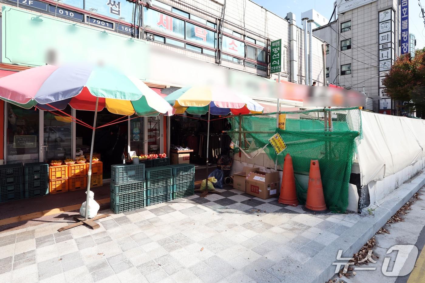 본문 이미지 - 16일 오후 전남광주 도시철도 2호선 출입구 조성이 한창인 서구 금호동의 한 아파트 상가 밀집 지역에서 공사 펜스와 안내판이 설치된 인근 상가 점포들의 모습. ⓒ 뉴스1 조수민 기자