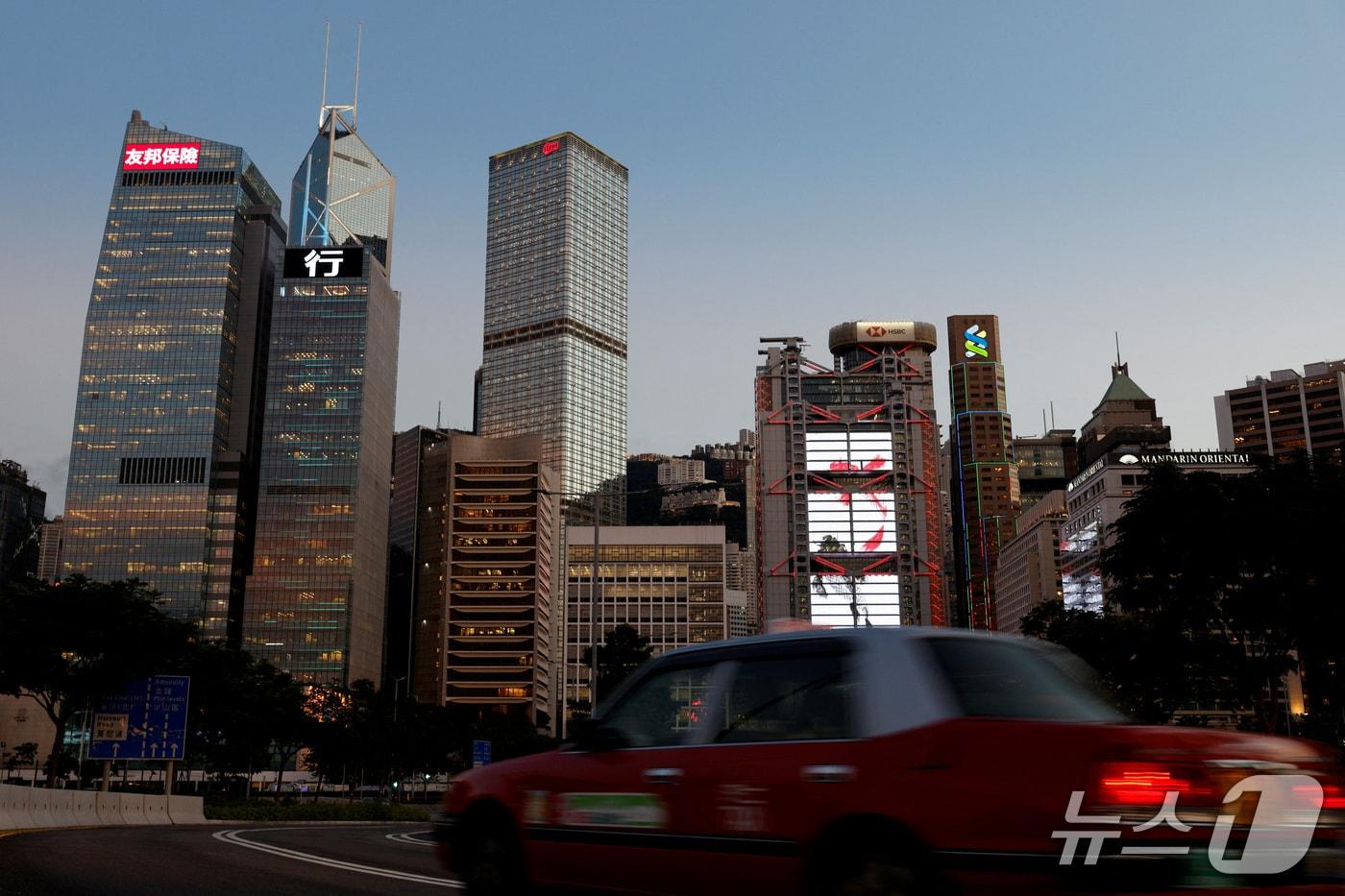 본문 이미지 - 지난 2021년 8월 17일(현지시간) 홍콩 센트럴 금융가에서 택시가 중국은행과 HSBC 등 주요 금융기관 건물 앞을 지나가고 있다.  <자료사진> 2021.8.17 ⓒ 로이터=뉴스1