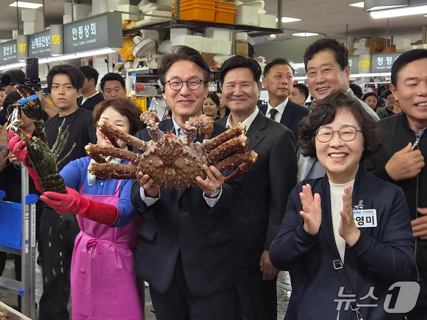 본문 이미지 - 부산 방문 이틀째인 17일 오전 더불어민주당 김민석 당대표가 부산 최대 수산시장인 자갈치시장을 찾아 상인이 건넨 대형 킹크랩을 직접 들어 보이며 활짝 웃고 있다. 오른쪽은 박영미 지역위원장. 2026.10.17뉴스1 ⓒ News1 임순택 기자