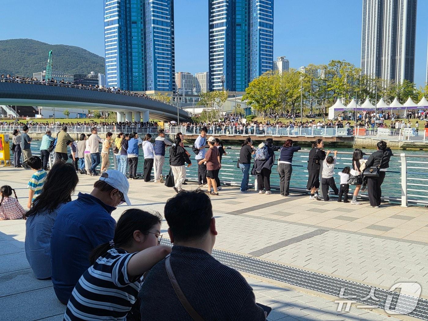 본문 이미지 - 17일 부산 동구 북항친수공원 인공수로 주변이 상어 '부캉이'를 보기 위해 모여든 시민들로 붐비고 있다. 지난달 18일 처음 나타난 부캉이는 출현 한 달 만에 누적 방문객 150만 명을 돌파하며 폭발적인 인기를 끌고 있다. 2026.10.17뉴스1 ⓒ News1 임순택 기자