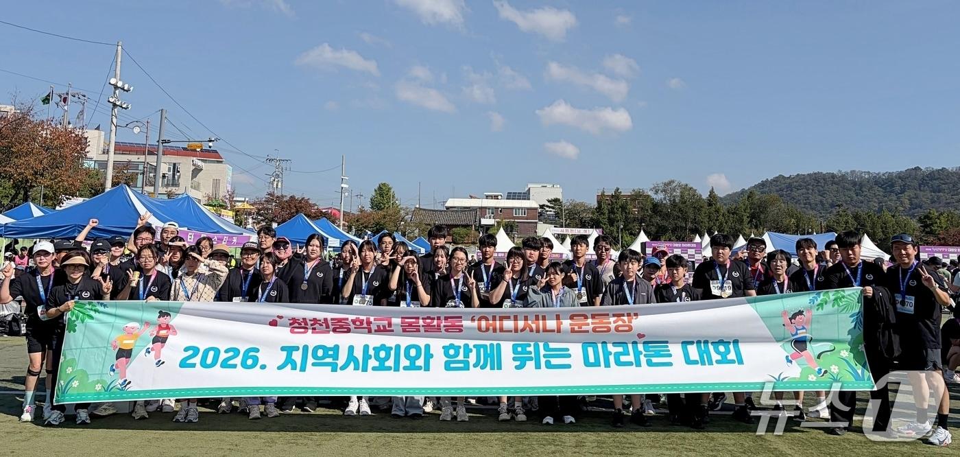 본문 이미지 - 24회 청원생명쌀 대청호 마라톤대회에 출전한 괴산청천중학교 학생과 학부모, 교직원들이 기념촬영을 하고 있다.(괴산증평교육지원청 제공. 재판매 및 DB 금지).2026.10.17/뉴스1