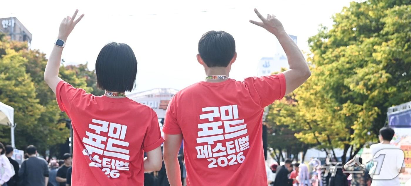 본문 이미지 - 17일 경북 구미 송정맛길에서 열린 푸드페스티벌에서 행사를 준비한 공무원들이 축제를 알리는 티셔츠를 입고 '많은 방문'을 호소하고 있다.2026.10.17 ⓒ 뉴스1 정우용 기자