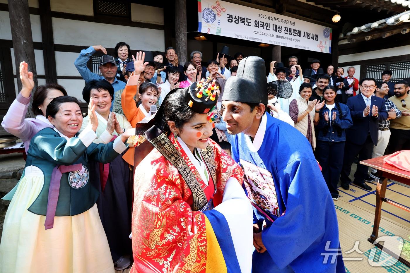 본문 이미지 - 17일 영남대 박물관 민속촌에서 전통혼례를 치른 신랑 바르가프 아키네팔리 씨와 신부 하리샤 아키네팔리 씨가 하객들의 축하를 받으며 입맞춤을 하고 있다. ⓒ 뉴스1 공정식 기자