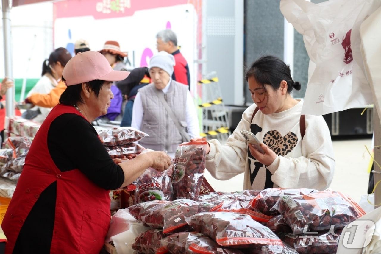 본문 이미지 - 18일 오전 보은대추축제장을 찾은 한 시민이 대추를 구입하고 있다.(보은군 제공. 재판매 및 DB 금지) 2026.10.18/뉴스1