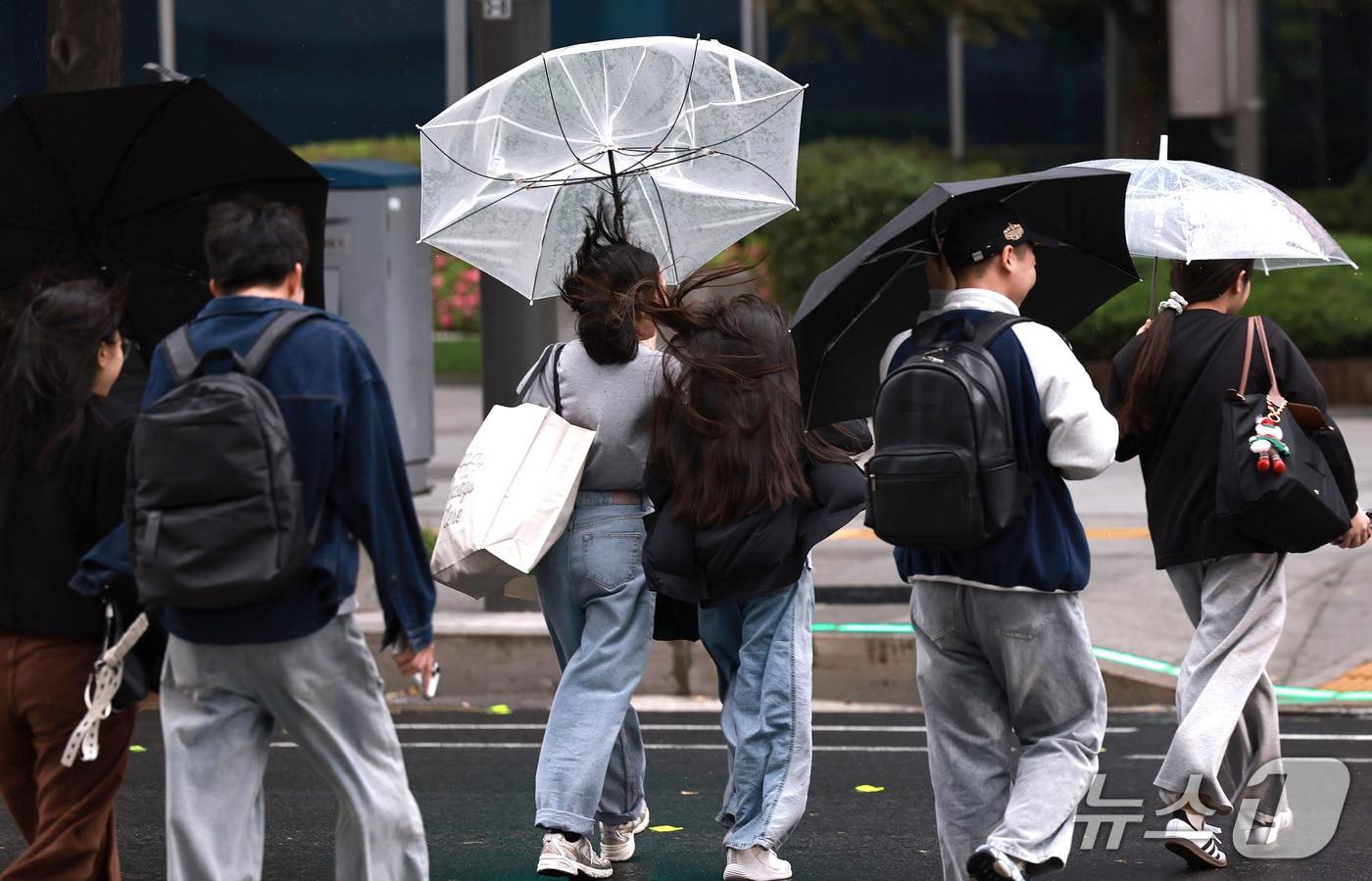 본문 이미지 - 18일 오후 서울 중구 을지로 일대에서 우산을 쓴 시민들이 비바람을 피하고 있다. 기상청은 이번 비가 19일까지 이틀간 이어지다가 북서쪽 찬 공기가 다시금 남하하면서 기온이 떨어질 것으로 내다봤다. 2026.10.18 ⓒ 뉴스1 구윤성 기자