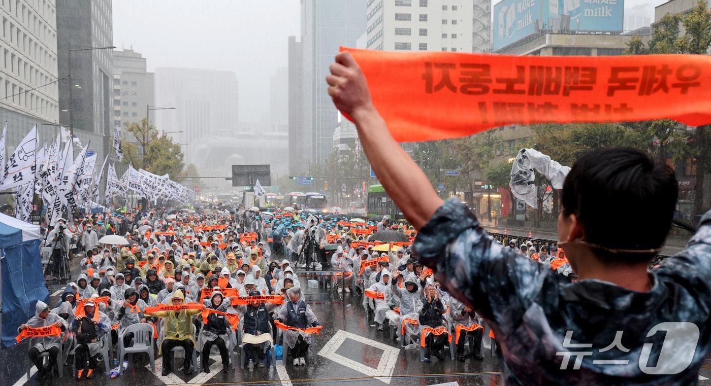 본문 이미지 - 18일 오후 서울 중구 숭례문 인근에서 열린 전국택배 노동자대회에서 참가자들이 수입감소 없는 주5일 쟁취 등을 촉구하며 손피켓을 들어보이고 있다. 2026.10.18 ⓒ 뉴스1 이광호 기자