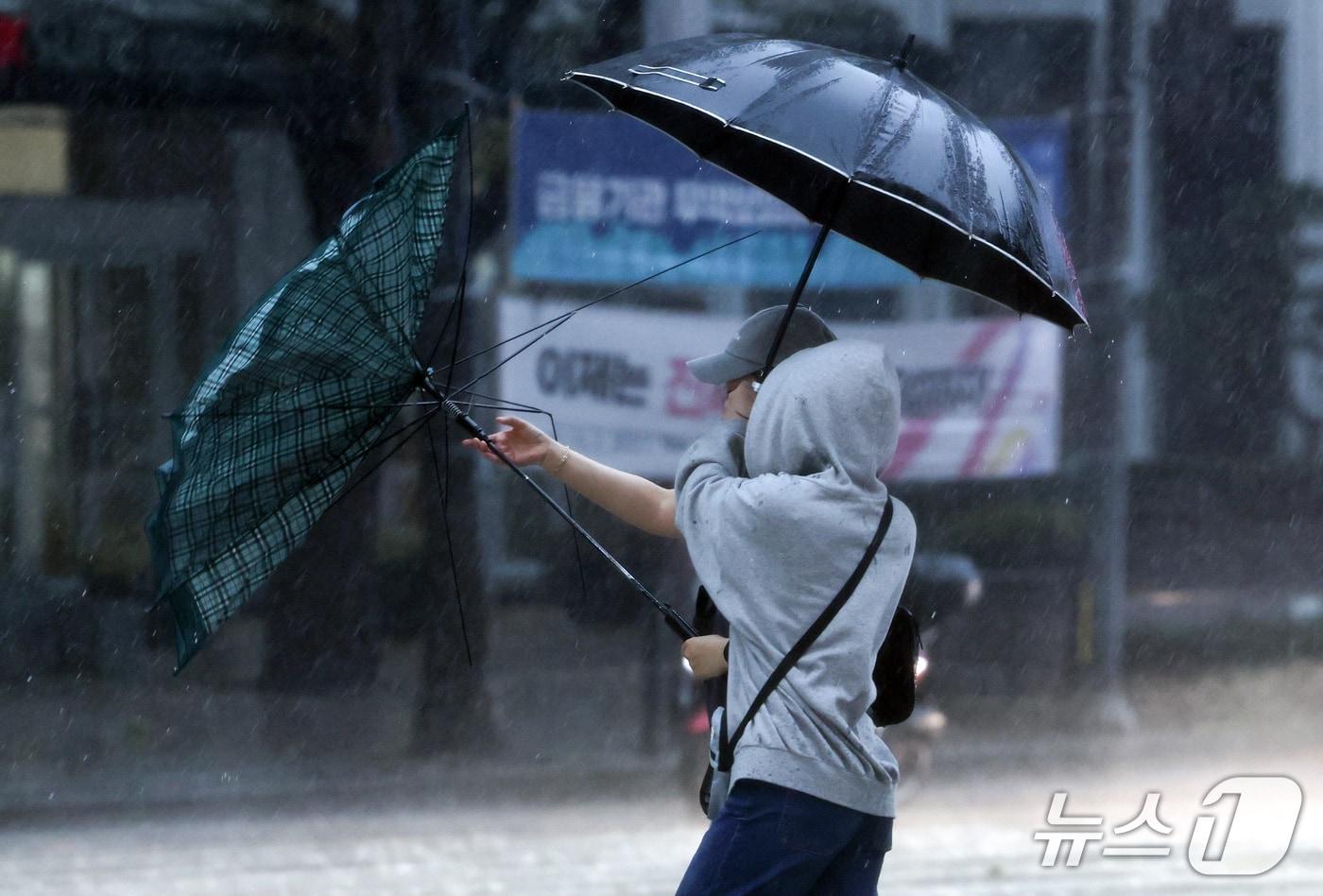 본문 이미지 - 중부 지방에 강풍을 동반한 강한 비가 내리는 18일 서울 종로구 종로1가 일대에서 시민들의 우산이 강한 바람에 뒤집혀 있다. 2026.10.18 ⓒ 뉴스1 최지환 기자