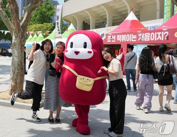 본문 이미지 - 대구 북구 떡볶이 페스티벌의 대표 캐릭터인 '뽀기'가 참가자들과 함께 기념촬영을 하고 있다.(대구 북구 제공. 재판매 및 DB 금지)/뉴스1