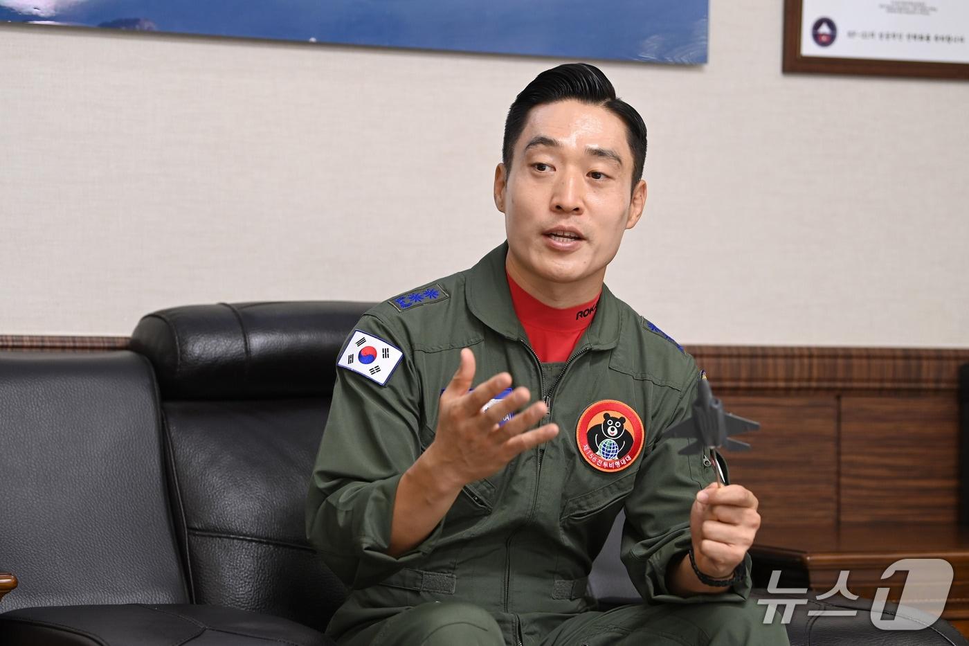 본문 이미지 - 14일 제156전투비행대대장 배중범 중령이 KF-21 모형을 들고 항공기 특성을 설명하고 있다. (공군 제공)