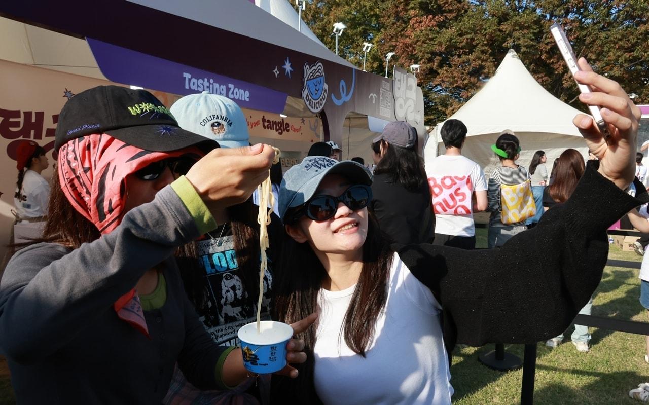 본문 이미지 - '그랜드민트페스티벌 2026' 방문객들이 삼양식품 프로틴 파스타 '탱글'을 시식하고 있다.(삼양식품 제공)
