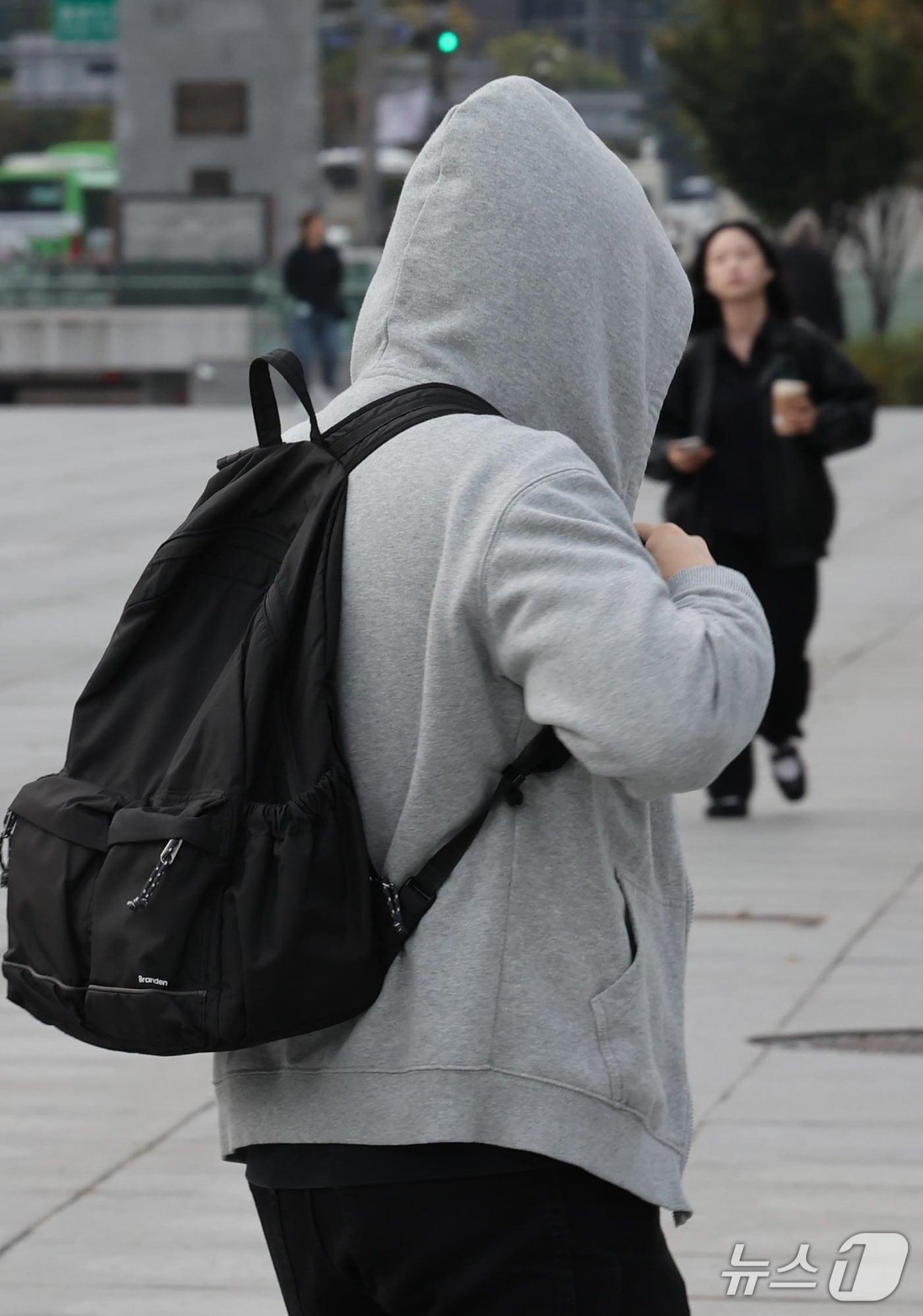 본문 이미지 - 지난 19일 가을비 내린 뒤 '쌀쌀한 출근길'에 서울 광화문 광장에서 한 남성이 모자 달린 외투를 입은 채 종종걸음 치고 있다. 2026.10.19 ⓒ 뉴스1 이종덕 기자