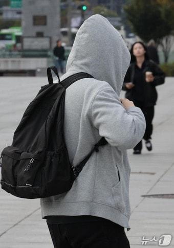 본문 이미지 - 19일 가을비 내린 뒤 '쌀쌀한 출근길'에 서울 광화문 광장에서 한 남성이 모자 달린 외투를 입은 채 종종걸음 치고 있다. 2026.10.19 ⓒ 뉴스1 이종덕 기자