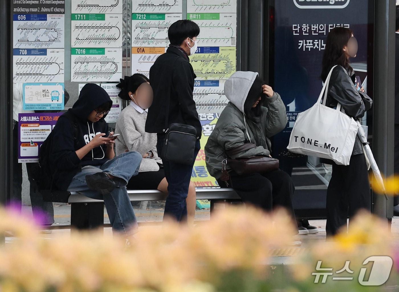 본문 이미지 - 19일 가을비 내린 뒤 '쌀쌀한 출근길'에 서울 세종로에서 시민들이 외투차림으로 버스를 기다리고 있다. 2026.10.19 ⓒ 뉴스1 이종덕 기자