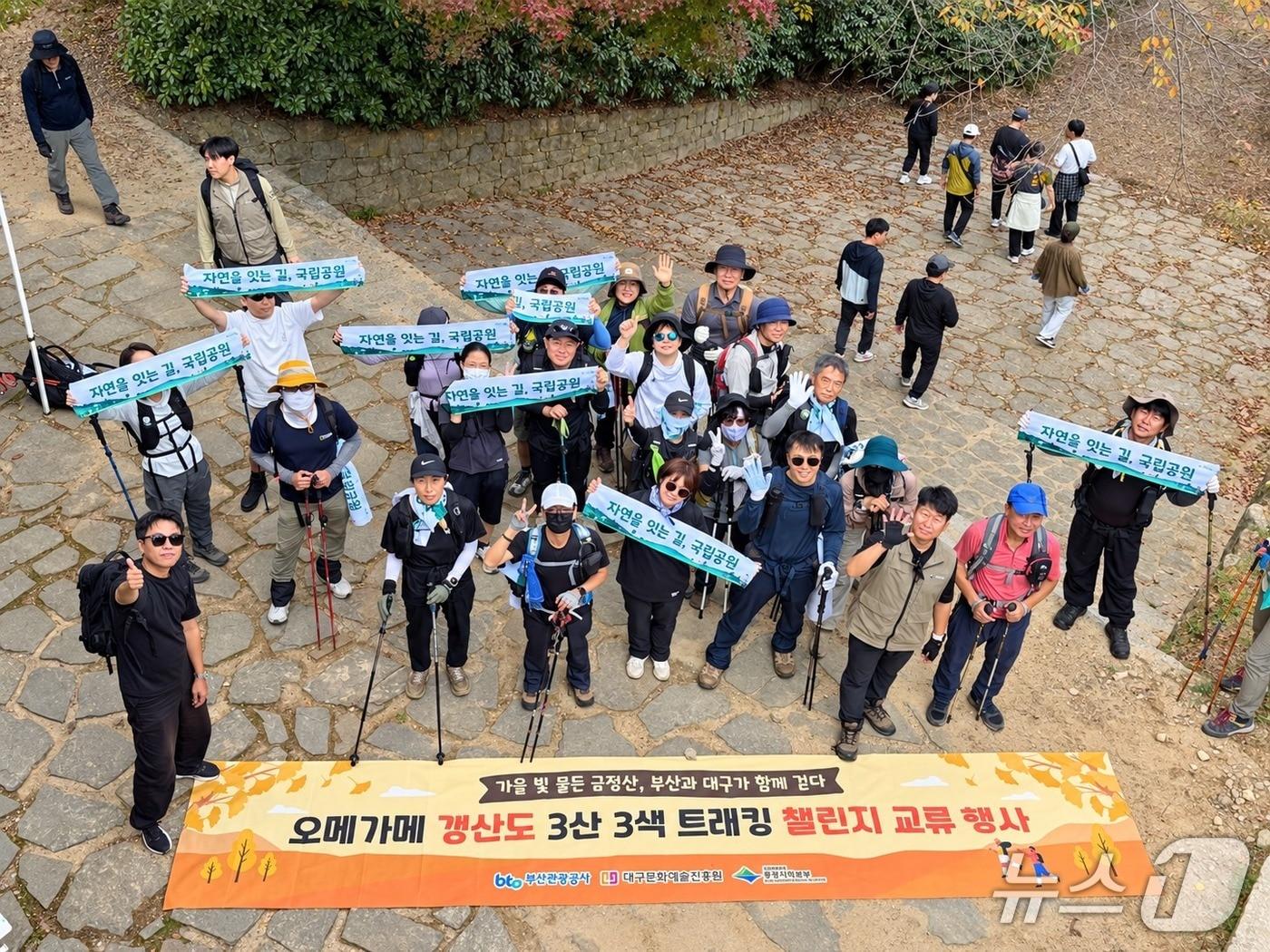 본문 이미지 - '오메가메 갱상도 3산 3색 트레킹 챌린지'와 연계한 금정산 교류 팸투어 참가자들이 기념사진을 찍고 있다.(부산관광공사 제공. 재판매 및 DB 금지)